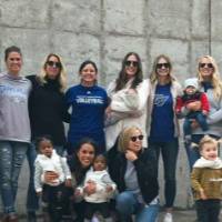 GVSU volleyball alumni and their kids pose for a photo outside